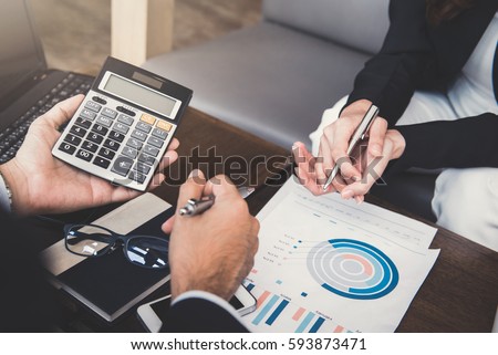 Financial adviser working with client, calculating and analyzing data at the table in cafe