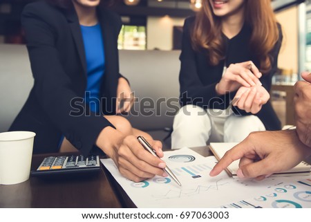 Financial adviser working with clients analyzing data at the table in cafe