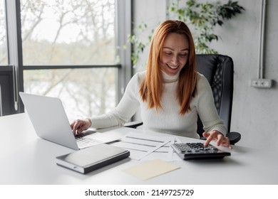 Financial Advisor Calculating And Working In An Office. Cheerful Mid Aged Accountant At Her Desk. Happy Woman Calculating.