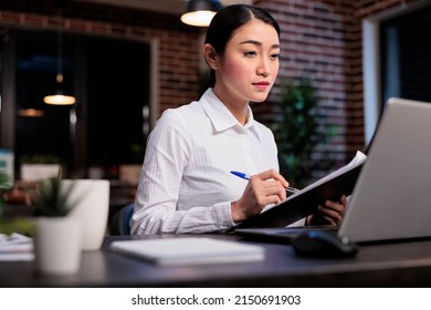 Financial Advisor With Clipboard Reviewing Marketing Campaign Paperwork While Analyzing Accounting Data. Business Company Employee In Office Workspace Signing Startup Project Documentation.