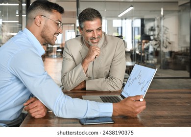 Financial advisor consulting investor explaining financial trade stock data using laptop computer. Professional analyst showing market trends in crypto exchange planning investment at office meeting. - Powered by Shutterstock