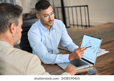 Financial advisor explaining invest stock market data consulting investor. Two busy business men analysts doing finance trading analysis pointing at exchange chart on laptop screen working in office. - Powered by Shutterstock