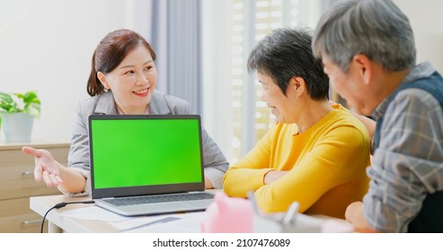 Financial Advisor Show Green Screen To Elderly Asian Couple By Laptop Computer