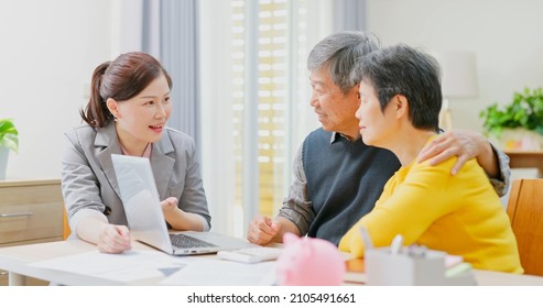 Financial Advisor Show Retirement Plan To Elderly Asian Couple By Laptop Computer At Home