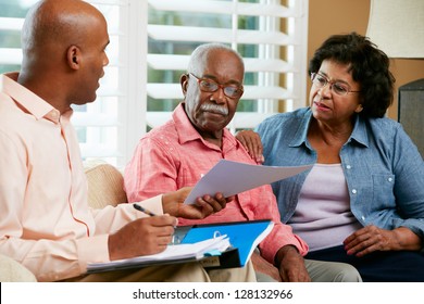 Financial Advisor Talking To Senior Couple At Home