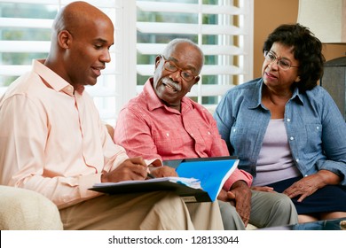 Financial Advisor Talking To Senior Couple At Home