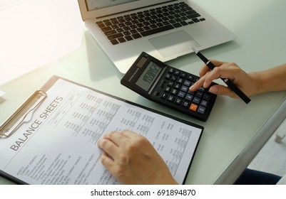 Financial advisor using calcualtor review financial statement on desk. top view. Accounting concept.