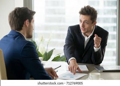 Financial analyst explaining reasons of company growth deceleration and giving advices how to reach success in next quarter. Businessman drawing attention of partner on value indicators during meeting - Shutterstock ID 712769005