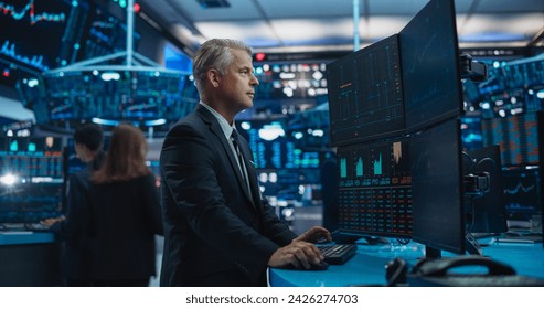 Financial Analyst Using Desktop Computer with Multi-Monitor Workstation with Real-Time Graphs, Financial Reports and Market Charts. Trader Working in a Modern Stock Exchange Business Venture
