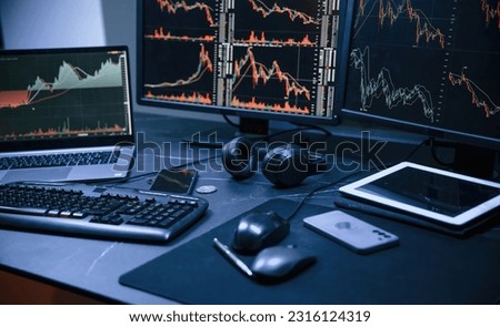 Financial Analyst Working on a Computer with Multi-Monitor Workstation with Real-Time Stocks, Commodities and Exchange Market Charts