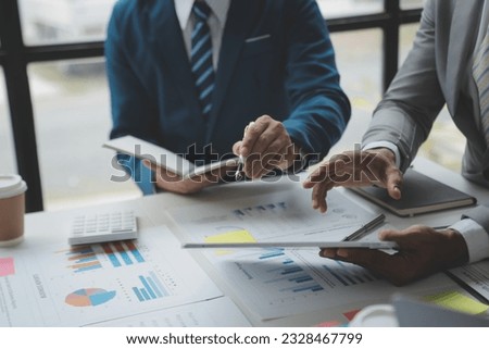 Financial analysts analyze business financial reports on a digital tablet planning investment project during a discussion at a meeting of corporate showing the results of their successful teamwork.