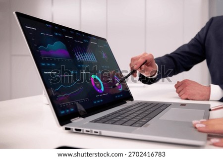 Financial Analysts Utilizing Dashboard Software On Laptop To Predict Market