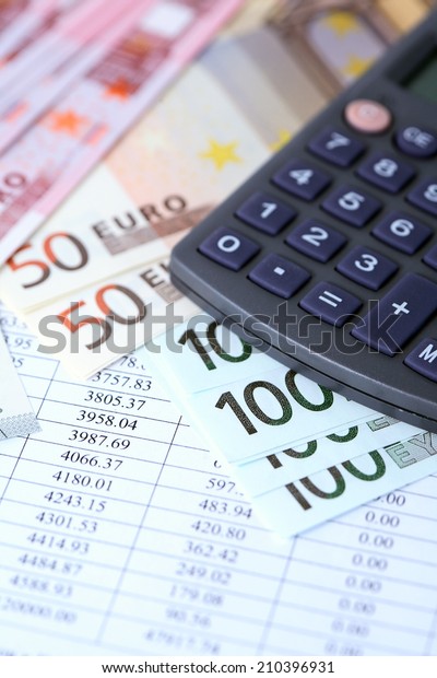 Financial background.\
European Union Currency near calculator on paper background with\
digits table