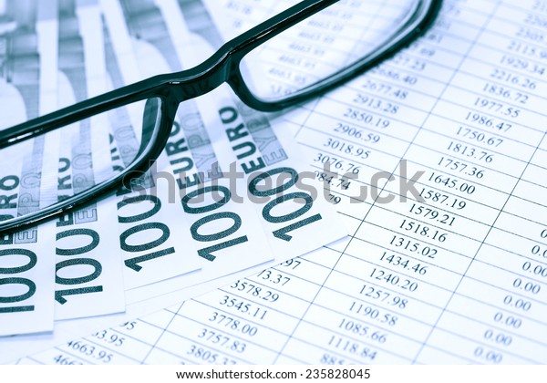 Financial background.\
European Union Currency near spectacles on paper background with\
digits table