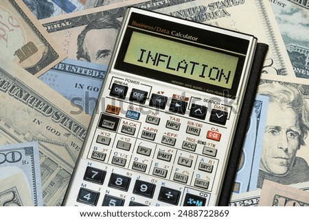 Financial calculator with word inflation on US currency. Concept of inflation, financial insecurity.
