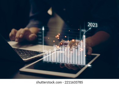 financial charts and graph analysis marketing showing growing revenue In 2023 floating above digital screen tablet, business about strategy for growth and success. - Shutterstock ID 2211633785