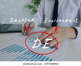 Financial Concept About DE Desktop Environment With Handwritten Note.Young Business Man Signing Documents On Background.
