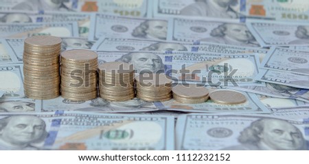 Financial concept image. Histogram of coins against the background of dollars.