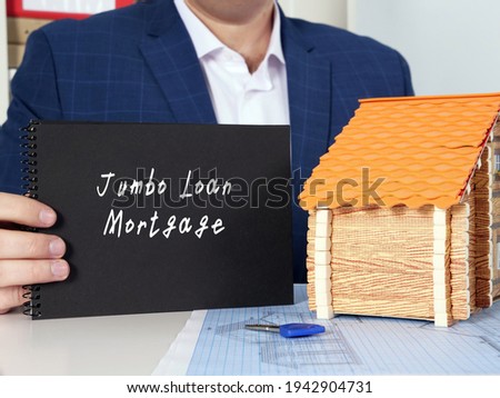 Financial concept meaning Jumbo Loan Mortgage with phrase on blank notepad in hand. 
