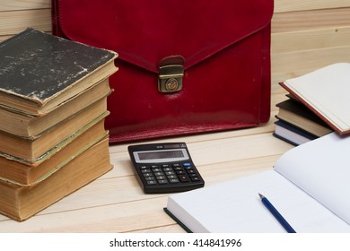 Financial concept. On a wooden table books, documents, calculator, red briefcase. Copy space