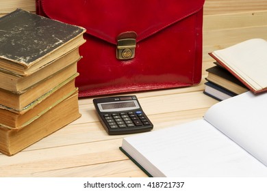 Financial concept. On a wooden table books, documents, calculator, red briefcase. Copy space