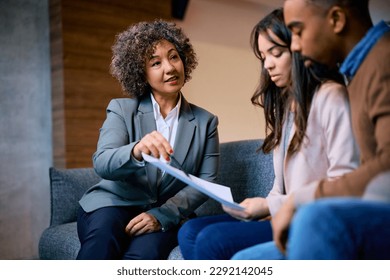 Financial consultant advising African American couple while analyzing their finances on a meeting in the office. - Powered by Shutterstock