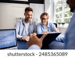 Financial consultant explaining new project investment to young couple in office. Real estate agent discussing mortgage options with family. Mortgage loan consultation with financial advisor.