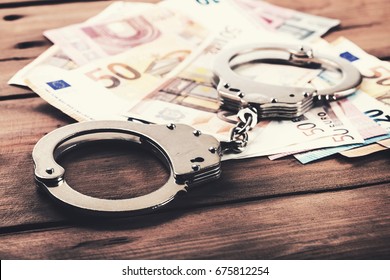 Financial Crime Concept - Money And Handcuffs On The Table