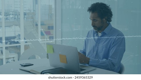 Financial data processing over caucasian man working on laptop in office. frances, global business, technology, digitally generated image.
