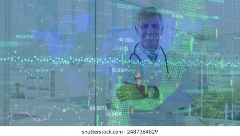 Financial data processing over world map against caucasian senior male doctor smiling at hospital. Medical healthcare and technology concept - Powered by Shutterstock