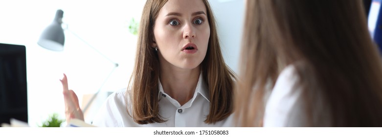 Financial department data verification and error. Woman expresses surprise at news that her colleague is telling. Detection data inconsistency in workplace. Girl holds an open folder with documents. - Powered by Shutterstock