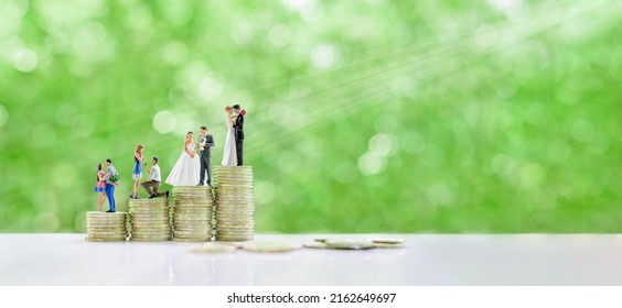Financial dependency for family life or married life concept : Miniature figurine young couple on coins, depicting investment or savings money for future expense or obligations for a newly wed family.