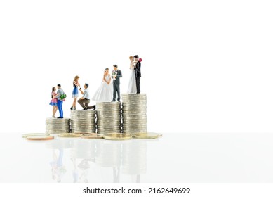 Financial dependency for family life or married life concept : Miniature figurine young couple on coins, depicting investment or savings money for future expense or obligations for a newly wed family.