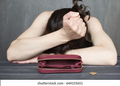 Financial difficulties concept, young frustrated woman sitting next to an old empty wallet.  - Shutterstock ID 644155651