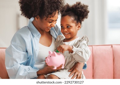 financial education. african american family, mother and child daughter with pig piggy bank counting savings at home on sofa
 - Powered by Shutterstock