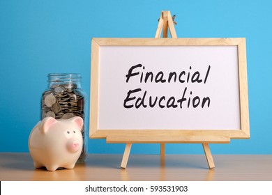 Financial Education,  Financial Concept. Mason Jar With Coins Inside, Piggy Bank And Whiteboard On Wooden Table.