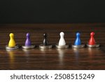 Financial equality. Colorful game pieces with similar quantity of coins on wooden table