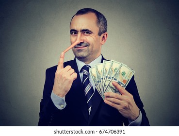 Financial fraud concept. Liar businessman with dollar cash 