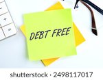 financial freedom concept. The words DEBT FREE on a sticker in a composition with a calculator and glasses on top on a white background