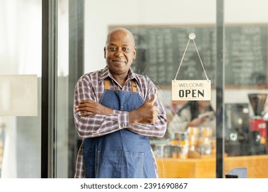 Financial freedom of small business Shot of a cheerful senior man smiling happily holding up an open sign posing at his own cafe in front of the door senior male standing his small business sme. - Powered by Shutterstock