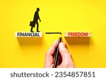 Financial freedom symbol. Concept words Financial freedom on beautiful wooden blocks. Beautiful yellow table yellow background. Businessman hand. Business financial freedom concept. Copy space.