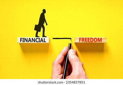 Financial freedom symbol. Concept words Financial freedom on beautiful wooden blocks. Beautiful yellow table yellow background. Businessman hand. Business financial freedom concept. Copy space.