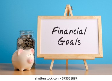 Financial Goals, Financial Concept. Mason Jar With Coins Inside, Piggy Bank And Whiteboard On Wooden Table.