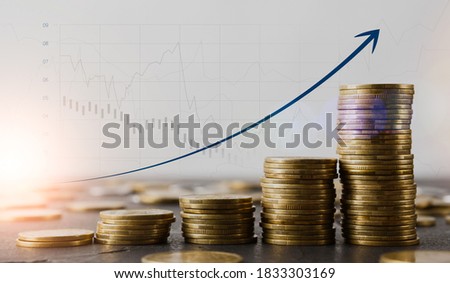 Financial growth concept. Stacks of gold coins on table and raising arrow over economic charts and diagrams on background, creative collage for business success or profit achievement, copy space