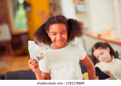 Financial Literacy. A Smiling Little Girl Holding A Pile Of Banknotes