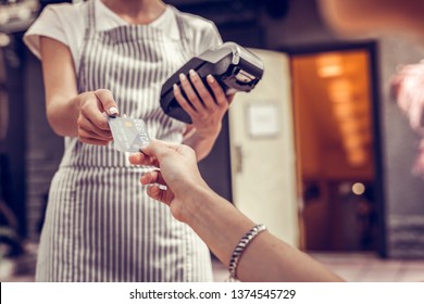 Financial Operations. Close Up Of A Debit Card Being In Use While Paying For The Order In The Cafe