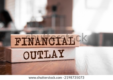 Financial Outlay text concept written on wooden blocks lying on a table