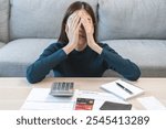 Financial owe asian woman sitting cover face with hands, stressed by calculate expense at home, cover her face, have no money to pay, mortgage or loan. Debt, bankruptcy or bankrupt concept.