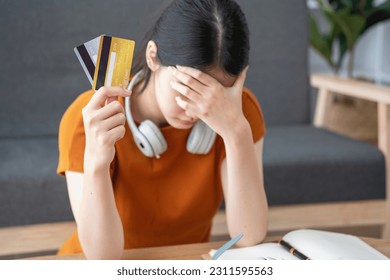 Financial owe, hand of asian woman sitting, holding many credit card, stressed by calculate expense from invoice or bill, no money to pay, mortgage or loan. Debt, bankruptcy or bankrupt - Shutterstock ID 2311595563