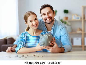 Finanzplanung glückliches Familienpaar mit Sparkasse zu Hause  